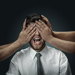 Image showing A young man surrounded by hands like his own thoughts