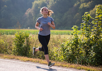 Image showing woman jogging along a country road