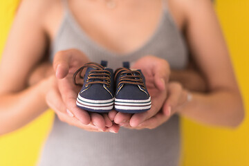 Image showing couple holding newborn baby shoes