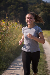 Image showing woman jogging along a country road