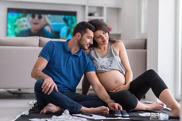 Image showing pregnant couple checking a list of things for their unborn baby