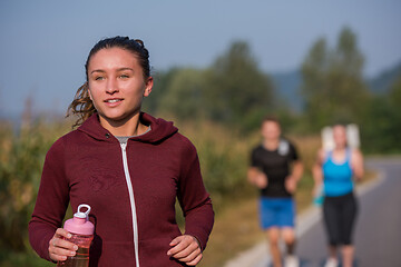 Image showing young people jogging on country road