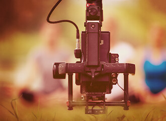 Image showing young videographer recording while woman doing yoga exercise