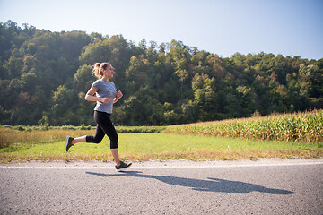 Image showing woman jogging along a country road