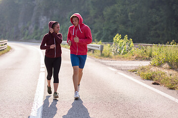 Image showing young couple jogging along a country road