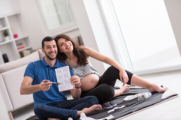 Image showing pregnant couple checking a list of things for their unborn baby