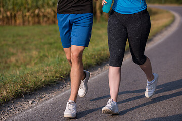 Image showing young couple jogging along a country road