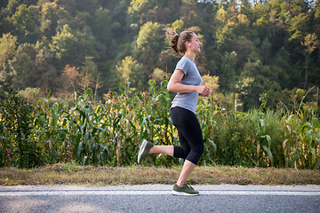 Image showing woman jogging along a country road
