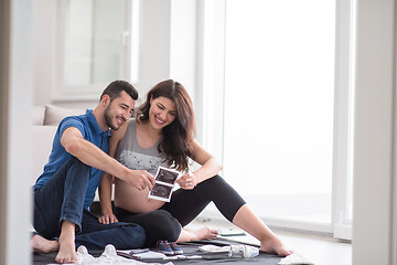 Image showing pregnant couple checking a list of things for their unborn baby