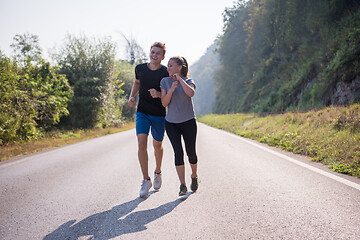 Image showing young couple jogging along a country road