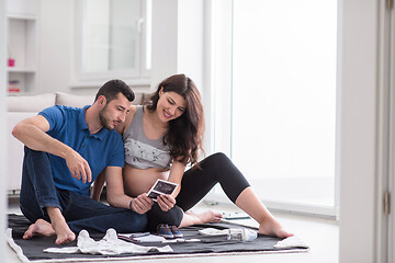 Image showing pregnant couple checking a list of things for their unborn baby