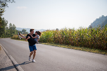 Image showing happy couple jogging along a country road