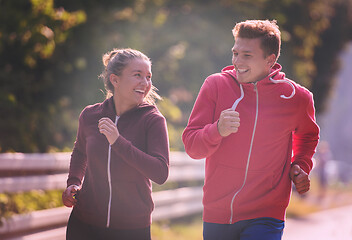 Image showing young couple jogging along a country road