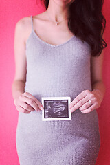 Image showing happy pregnant woman showing ultrasound picture
