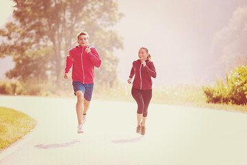 Image showing young couple jogging along a country road