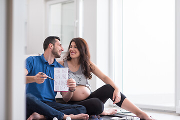 Image showing pregnant couple checking a list of things for their unborn baby