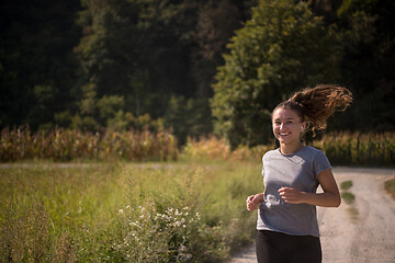 Image showing woman jogging along a country road