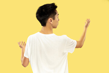 Image showing Korean young man\'s half-length portrait on yellow background