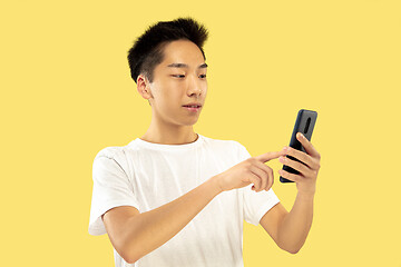 Image showing Korean young man\'s half-length portrait on yellow background