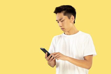 Image showing Korean young man\'s half-length portrait on yellow background