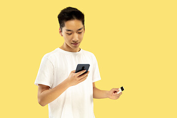 Image showing Korean young man\'s half-length portrait on yellow background