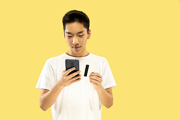 Image showing Korean young man\'s half-length portrait on yellow background