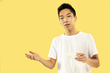 Image showing Korean young man\'s half-length portrait on yellow background