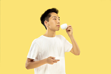 Image showing Korean young man\'s half-length portrait on yellow background