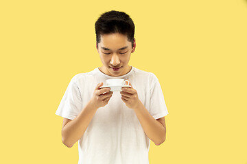 Image showing Korean young man\'s half-length portrait on yellow background