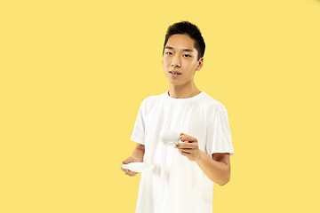 Image showing Korean young man\'s half-length portrait on yellow background