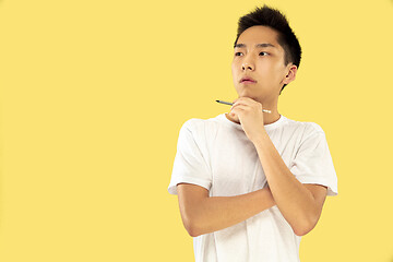 Image showing Korean young man\'s half-length portrait on yellow background