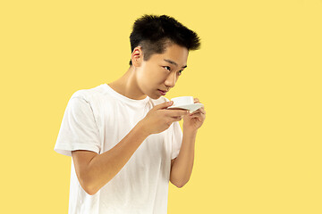 Image showing Korean young man\'s half-length portrait on yellow background