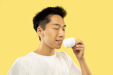 Image showing Korean young man\'s half-length portrait on yellow background