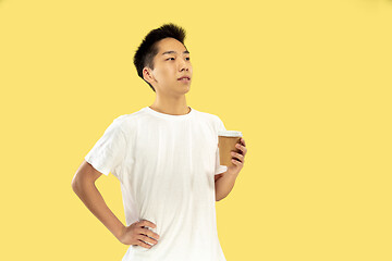 Image showing Korean young man\'s half-length portrait on yellow background