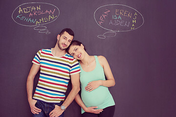 Image showing pregnant couple writing on a black chalkboard