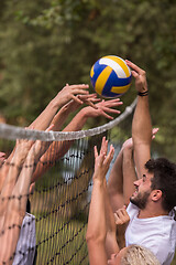 Image showing group of young friends playing Beach volleyball