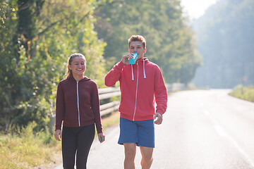 Image showing young couple jogging along a country road