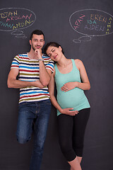 Image showing pregnant couple writing on a black chalkboard