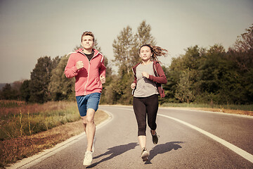 Image showing young couple jogging along a country road