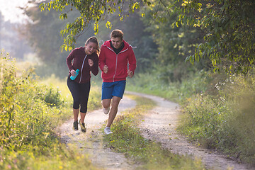 Image showing young couple jogging along a country road