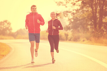 Image showing young couple jogging along a country road