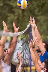 Image showing group of young friends playing Beach volleyball