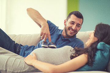 Image showing young pregnant couple relaxing on sofa