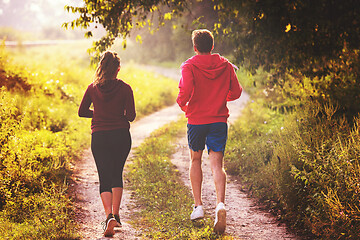 Image showing young couple jogging along a country road