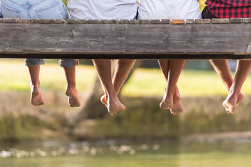 Image showing people sitting at wooden bridge