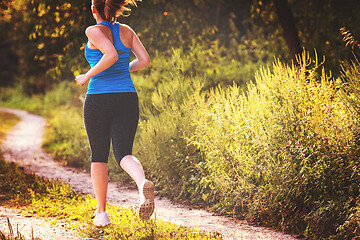 Image showing woman jogging along a country road