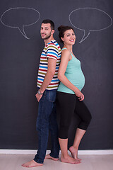 Image showing pregnant couple writing on a black chalkboard