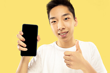 Image showing Korean young man\'s half-length portrait on yellow background