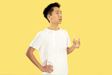 Image showing Korean young man\'s half-length portrait on yellow background