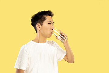 Image showing Korean young man\'s half-length portrait on yellow background